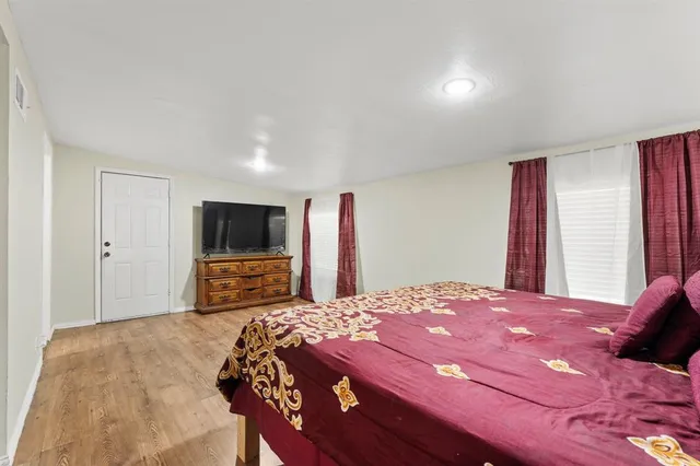 a bedroom with a bed and a flat screen tv