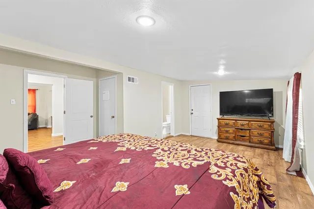 a bedroom with a bed and a flat screen tv