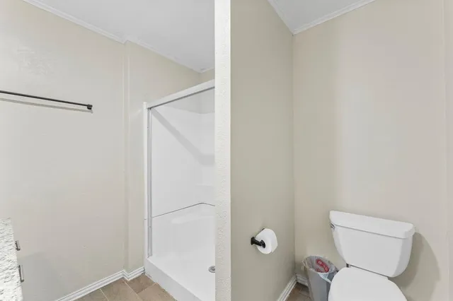 a white toilet sitting next to a shower