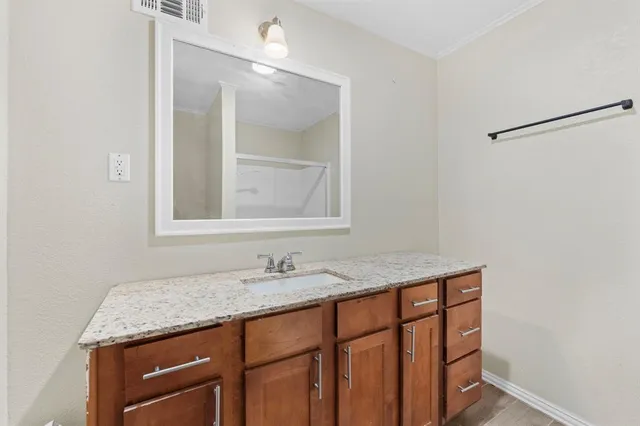 a bathroom with a granite countertop sink and a mirror