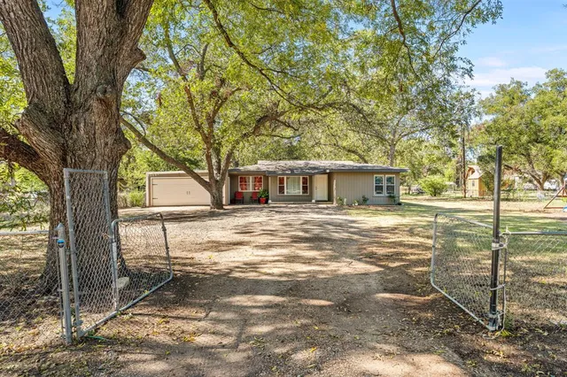 a view of a house with backyard and a tree