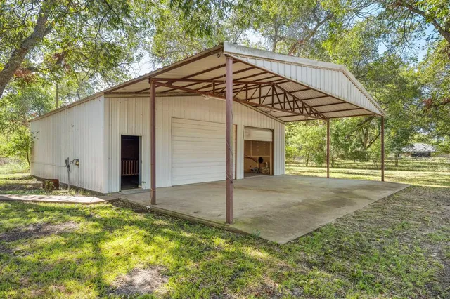 a view of a house with backyard and trees