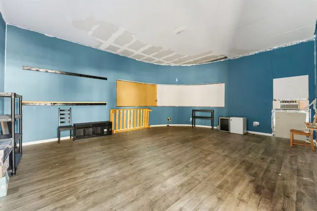 a view of an empty room with a window and fireplace