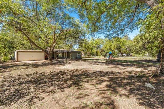 a front view of a house with a yard and trees