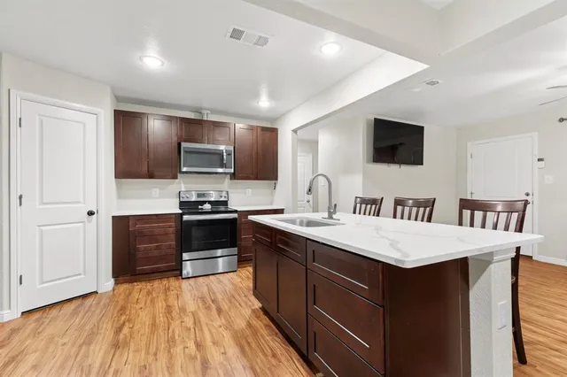 a large kitchen with kitchen island a sink appliances and cabinets