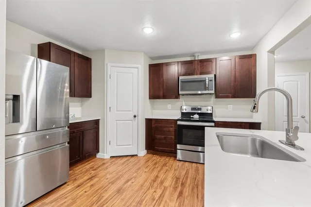 a kitchen with stainless steel appliances granite countertop a refrigerator stove and sink