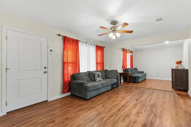 a living room with furniture and a wooden floor