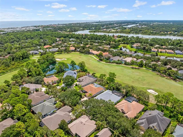 an aerial view of residential houses with outdoor space and trees all around