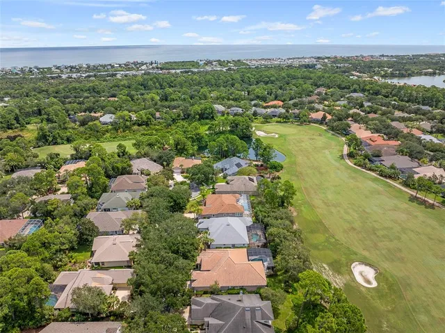 front view of a house with a yard and palm trees
