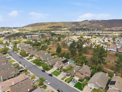 an aerial view of residential houses with outdoor space and trees