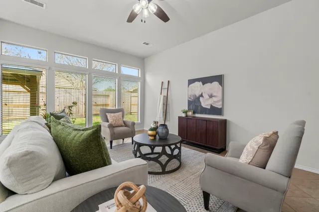 a living room with furniture a chandelier and a dining table