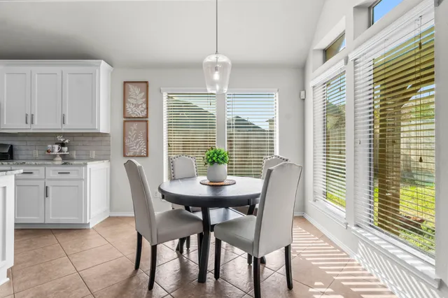 a dining room with furniture a chandelier and kitchen view