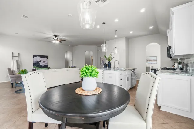 a kitchen with white cabinets and sink