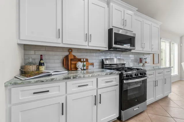a large kitchen with kitchen island a chandelier and living room view