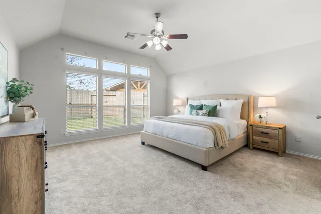 a spacious bedroom with a bed and a chandelier