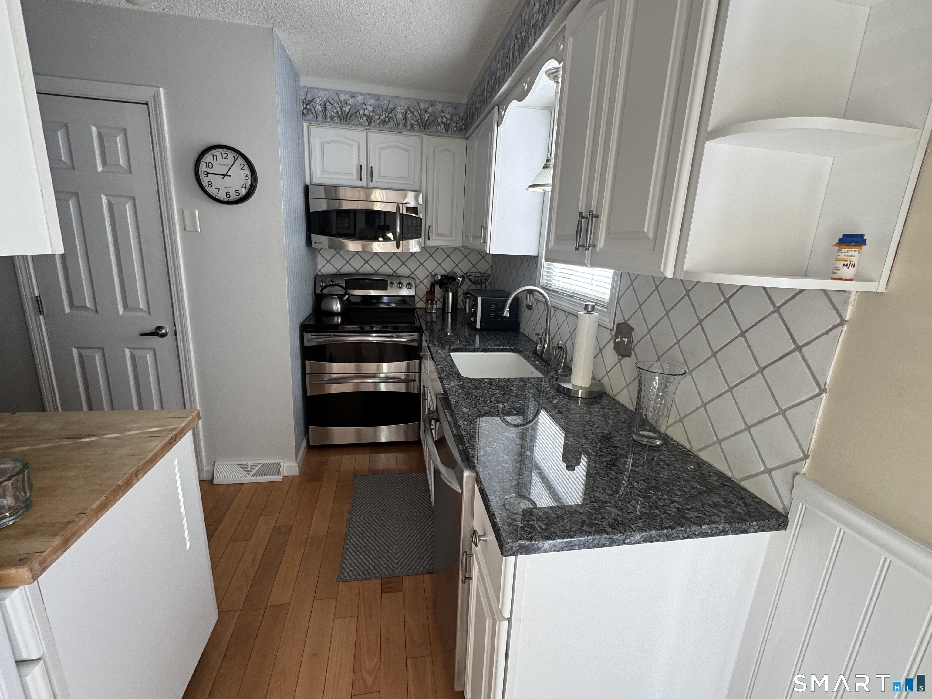 7 Bay Path Way, Unit 7 Branford, CT 06405 - Photo 8 of 14 a kitchen with granite countertop a refrigerator a stove and a sink