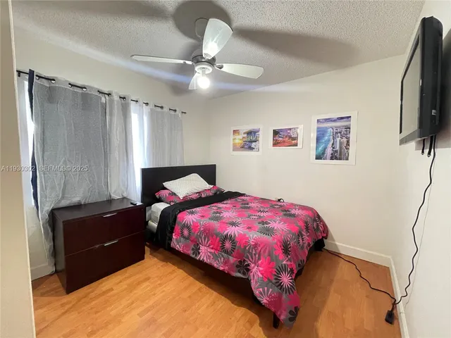 a bedroom with a bed and a flat tv screen on the dresser
