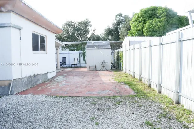 a backyard of a house with plants and trees