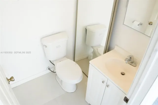 a bathroom with a sink and mirror with toilet