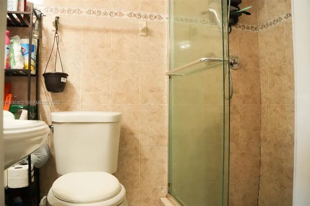 a white toilet sitting next to a bathroom sink