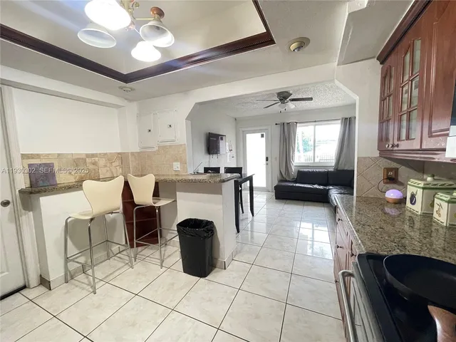 a kitchen with granite countertop a stove a sink and a refrigerator