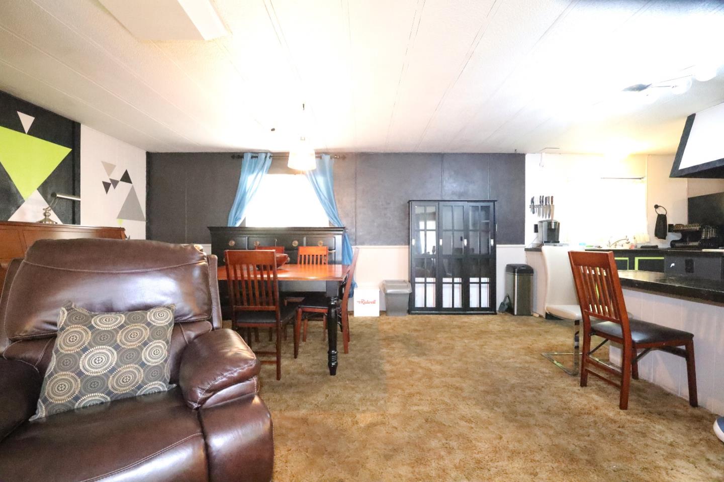 5450 Monterey Road, Unit 143 San Jose, CA 95111 - Photo 19 of 21 a living room with furniture and a dining table with projector the kitchen