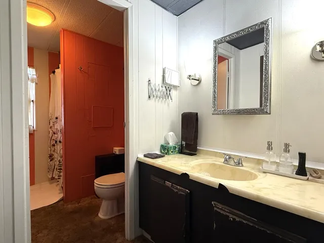 a bathroom with a granite countertop sink toilet and shower