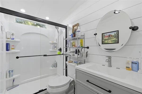 a bathroom with a sink a toilet and shower