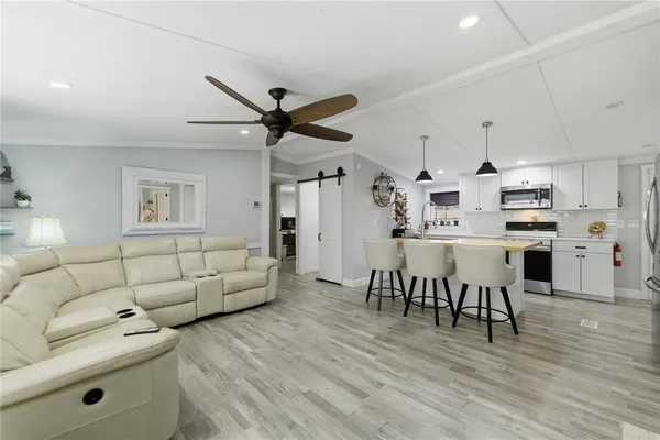 a living room with furniture and a large window with wooden floor