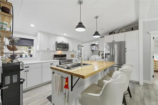 a kitchen with stainless steel appliances a stove a sink and a refrigerator