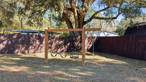 a view of outdoor space with wooden fence and a bench
