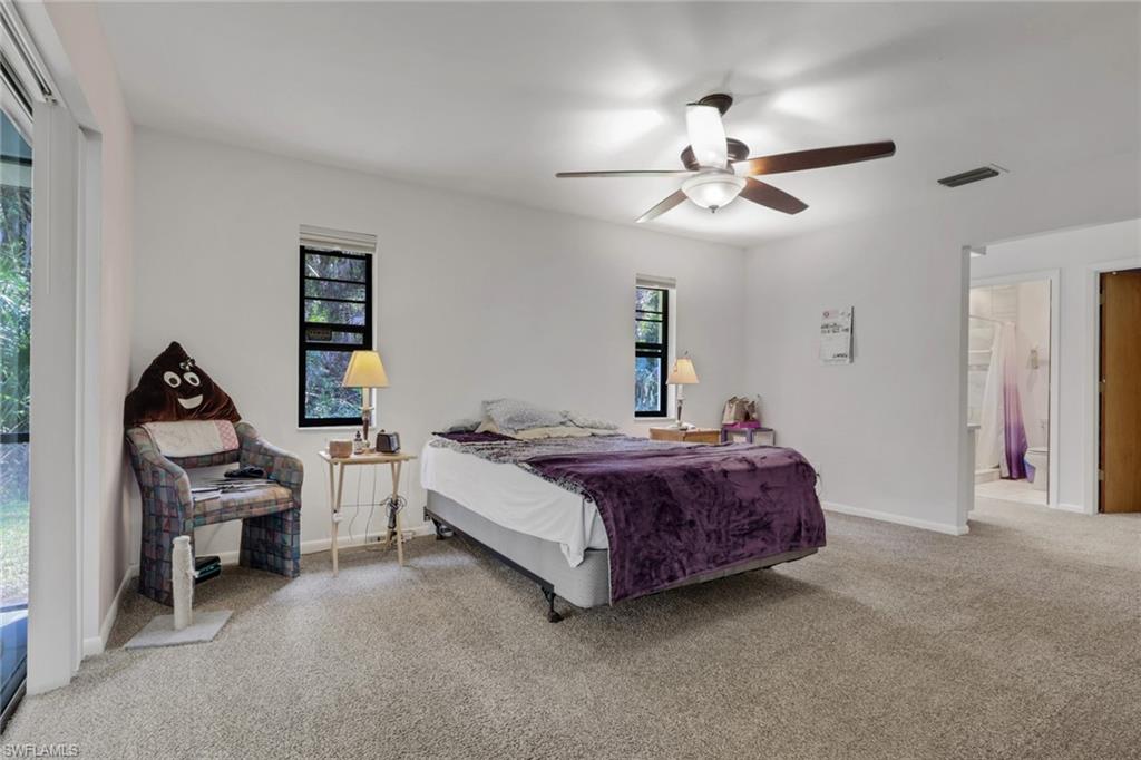 760 1st Street Northwest Naples, FL 34120 - Photo 15 of 36 a spacious bedroom with a bed and a chandelier