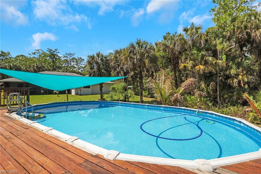 760 1st Street Northwest Naples, FL 34120 - Photo 16 of 36 a view of a swimming pool with an outdoor seating and a yard