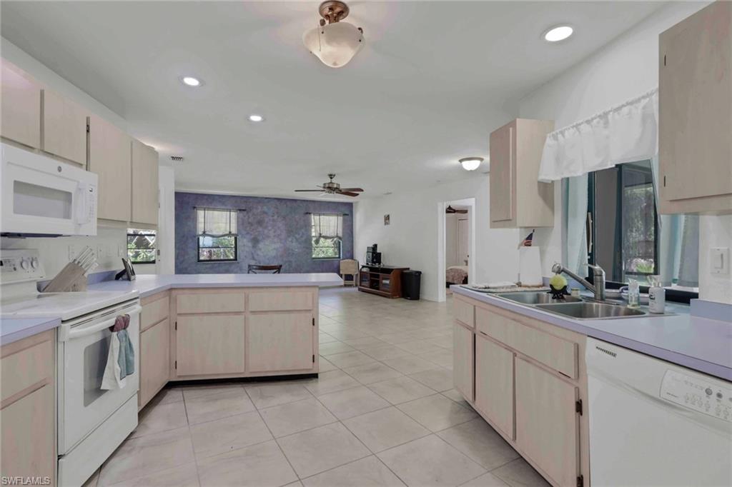 760 1st Street Northwest Naples, FL 34120 - Photo 18 of 36 a large white kitchen with cabinets a sink and appliances