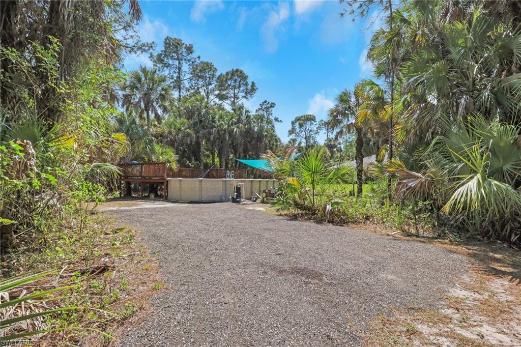 760 1st Street Northwest Naples, FL 34120 - Photo 25 of 36 a backyard of a house with plants and trees