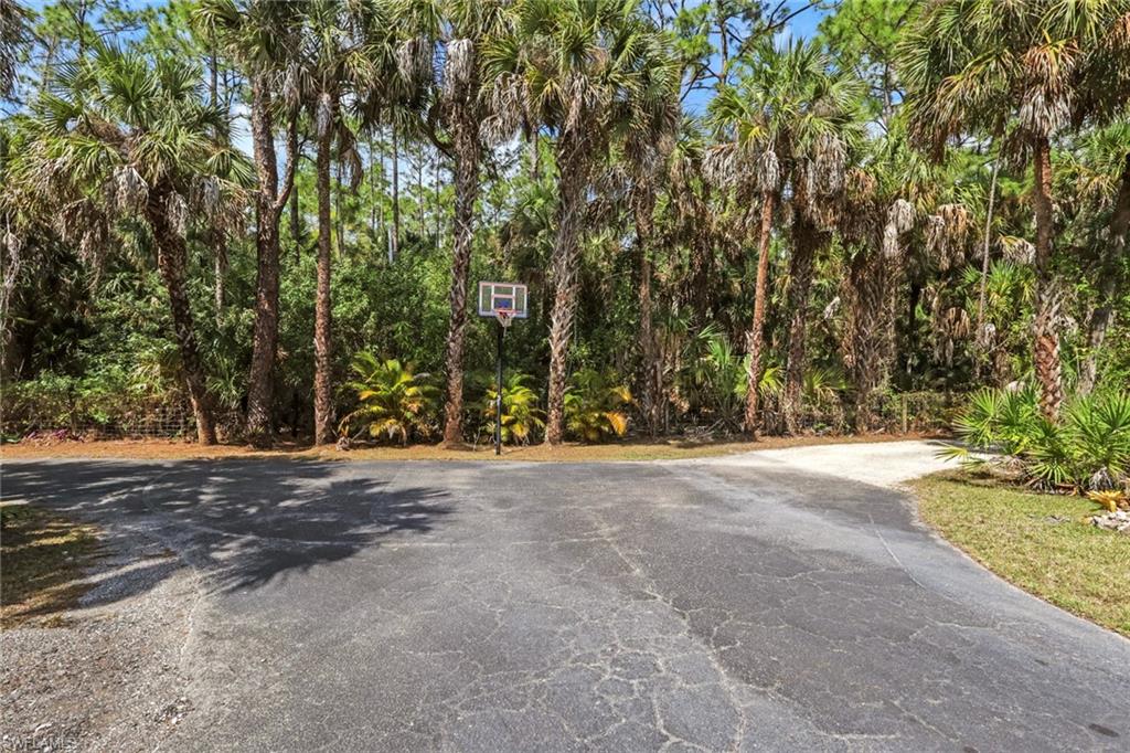 760 1st Street Northwest Naples, FL 34120 - Photo 28 of 36 Front Entrance with asphalt wrap around driveway, basketball hoop, firepit, space to park/charge your RV, etc.