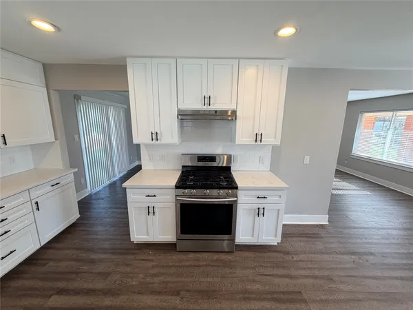 a kitchen with a stove and white cabinets