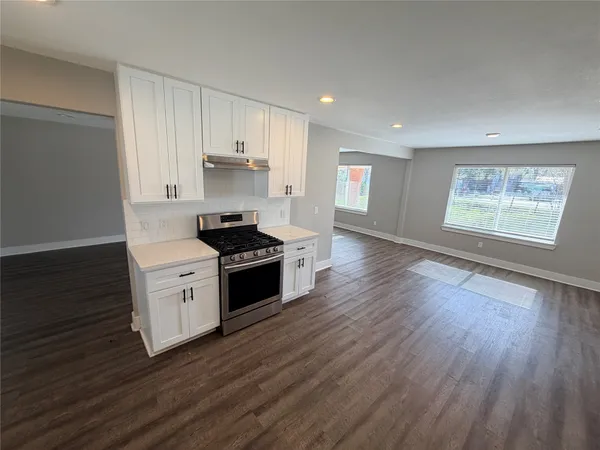 a kitchen with granite countertop wooden floors and black appliances
