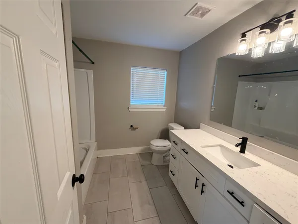 a bathroom with a double vanity sink a toilet and a mirror