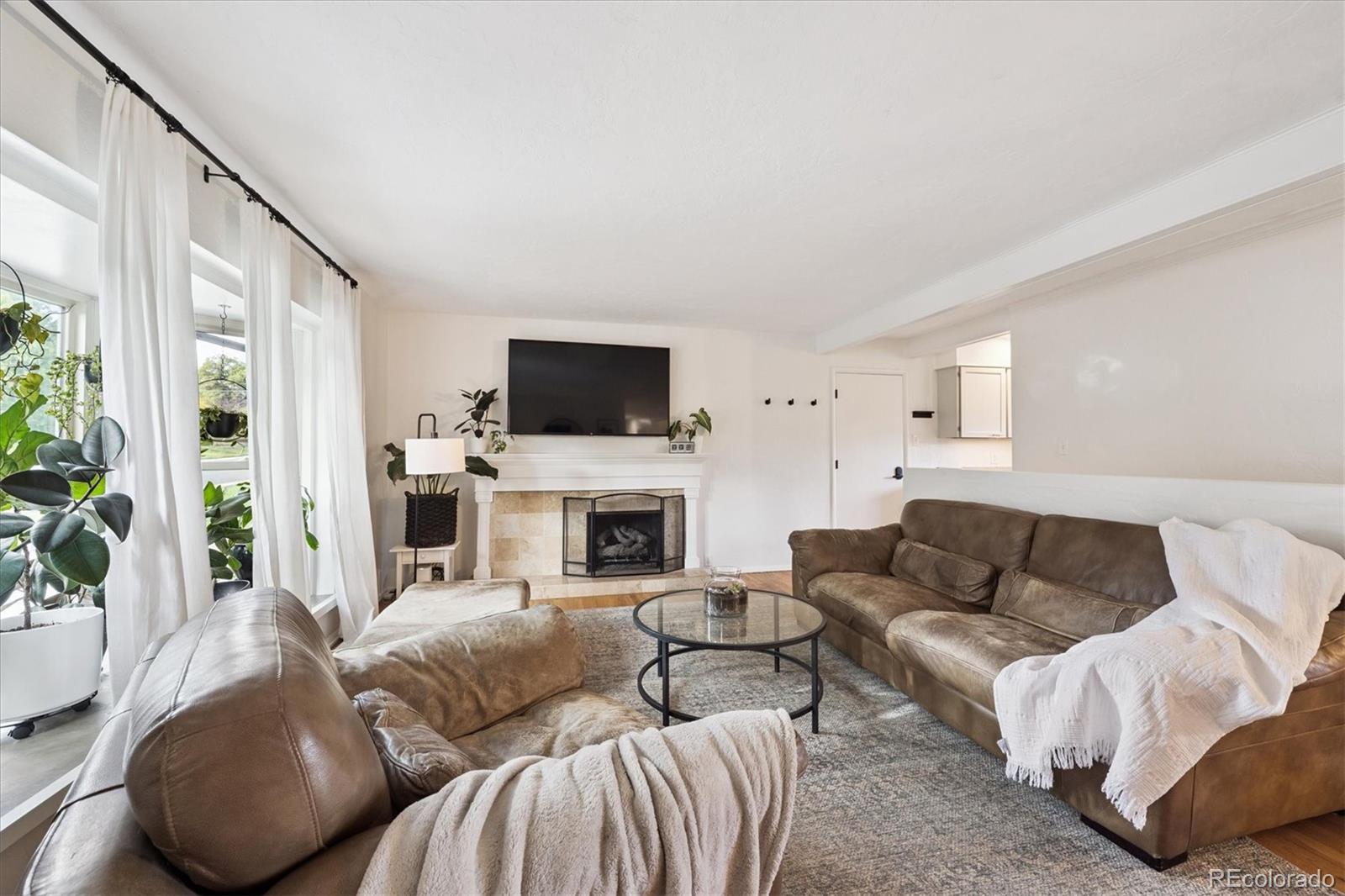 a living room with furniture a fireplace and a flat screen tv