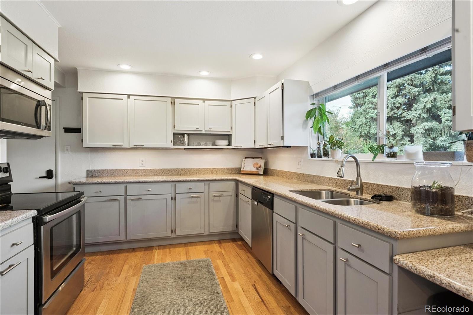 3675 South Hibiscus Way Denver, CO 80237 - Photo 15 of 50 a kitchen with a sink stove and microwave