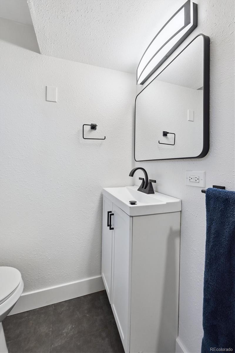 3675 South Hibiscus Way Denver, CO 80237 - Photo 42 of 50 a bathroom with a toilet a sink and mirror