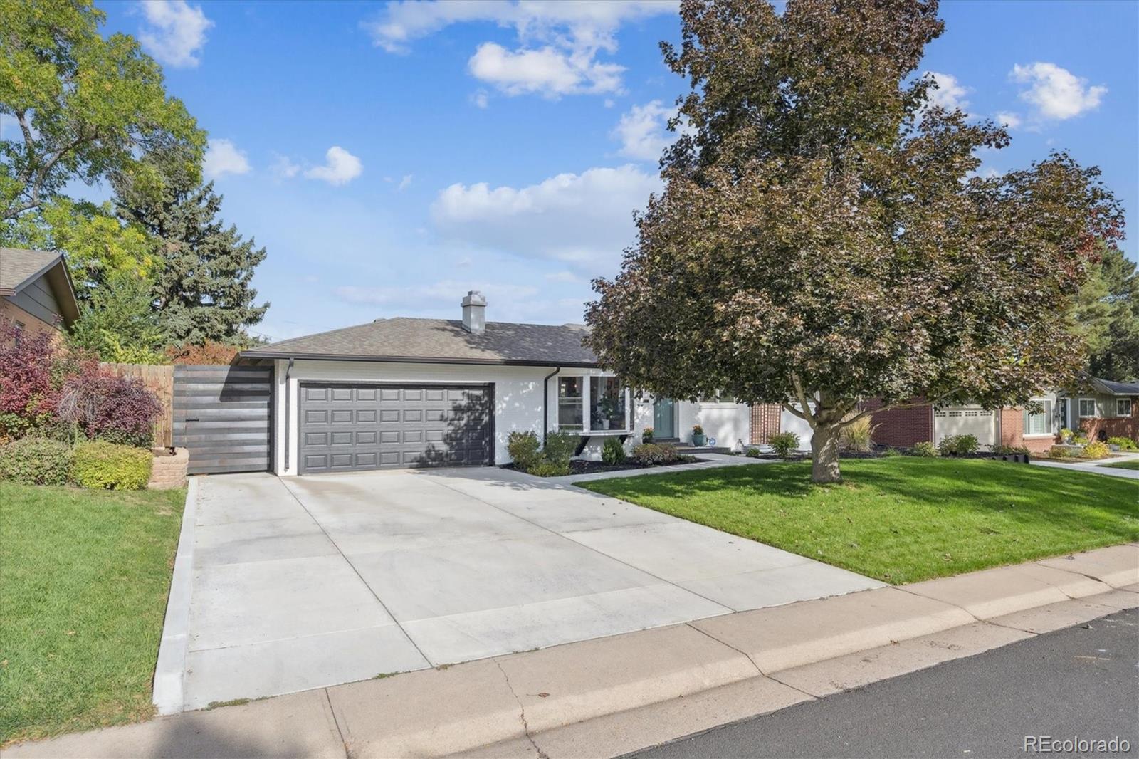 3675 South Hibiscus Way Denver, CO 80237 - Photo 5 of 50 a front view of a house with a garden and trees