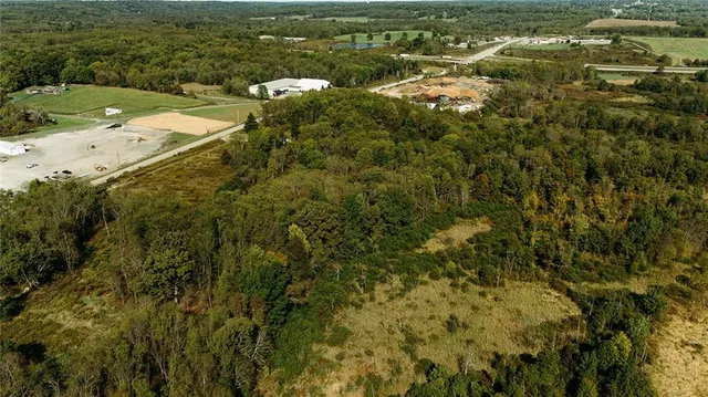 an aerial view of residential houses with outdoor space and trees