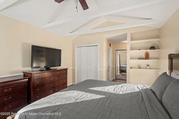 a bedroom with a bed and a flat screen tv on a dresser