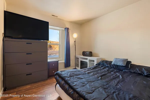 a bedroom with a bed and flat screen tv