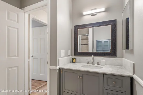 a bathroom with a granite countertop sink and a mirror