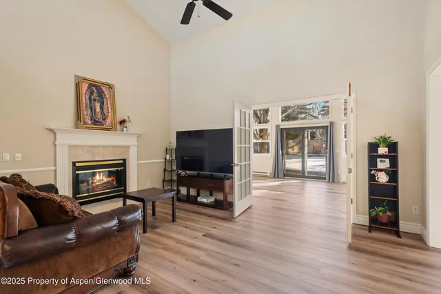 a view of a hallway with wooden floor and a bathroom