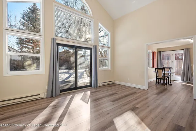 a kitchen with stainless steel appliances granite countertop a refrigerator a stove a sink dishwasher a dining table and chairs with wooden floor