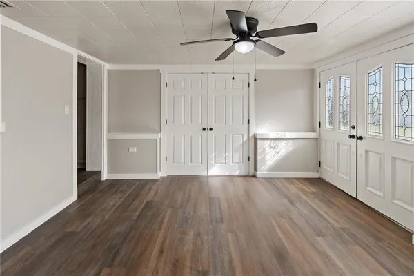 a view of empty room with wooden floor and ceiling fan